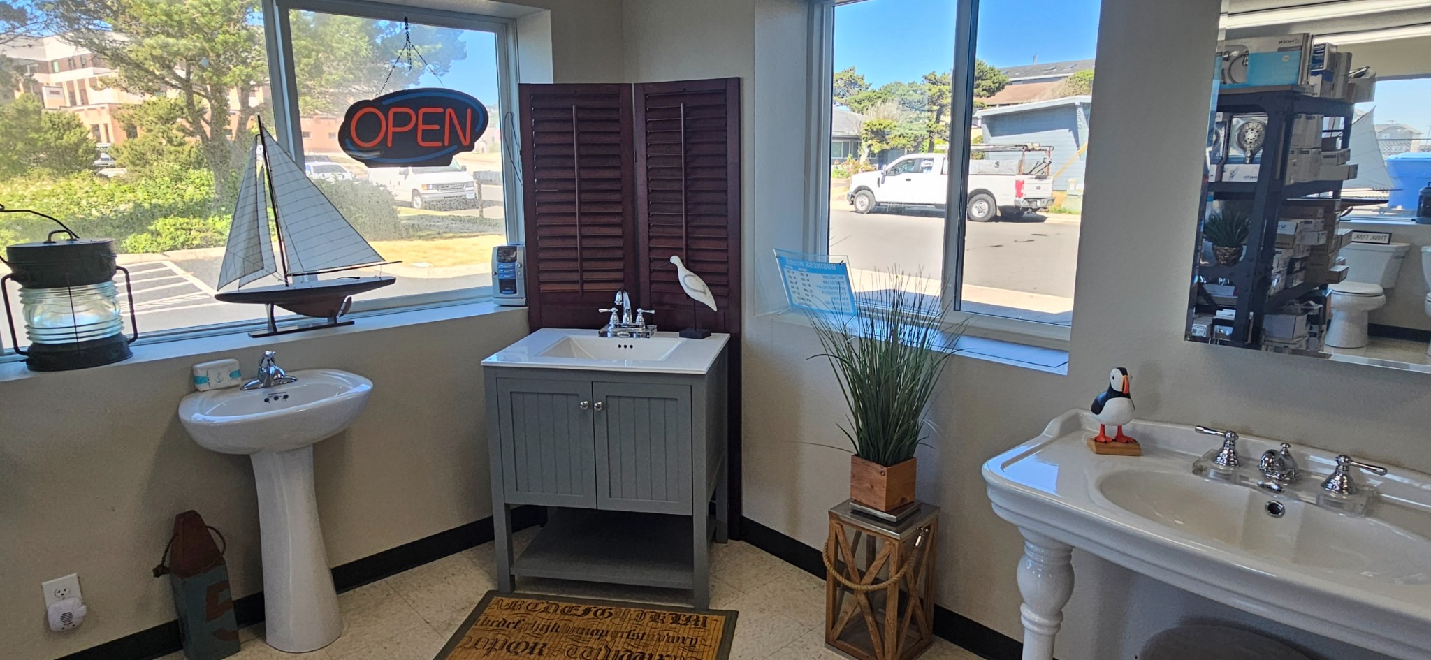 Pedestal and vanity sinks displayed beside the showroom windows