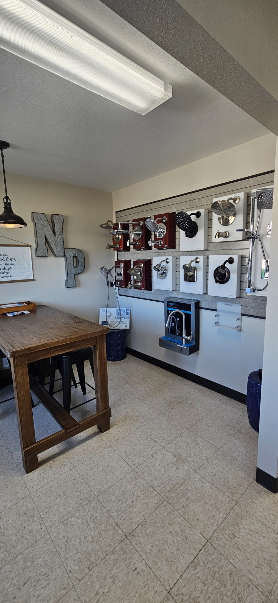 Showroom shower and valve display beside a wooden consultation table